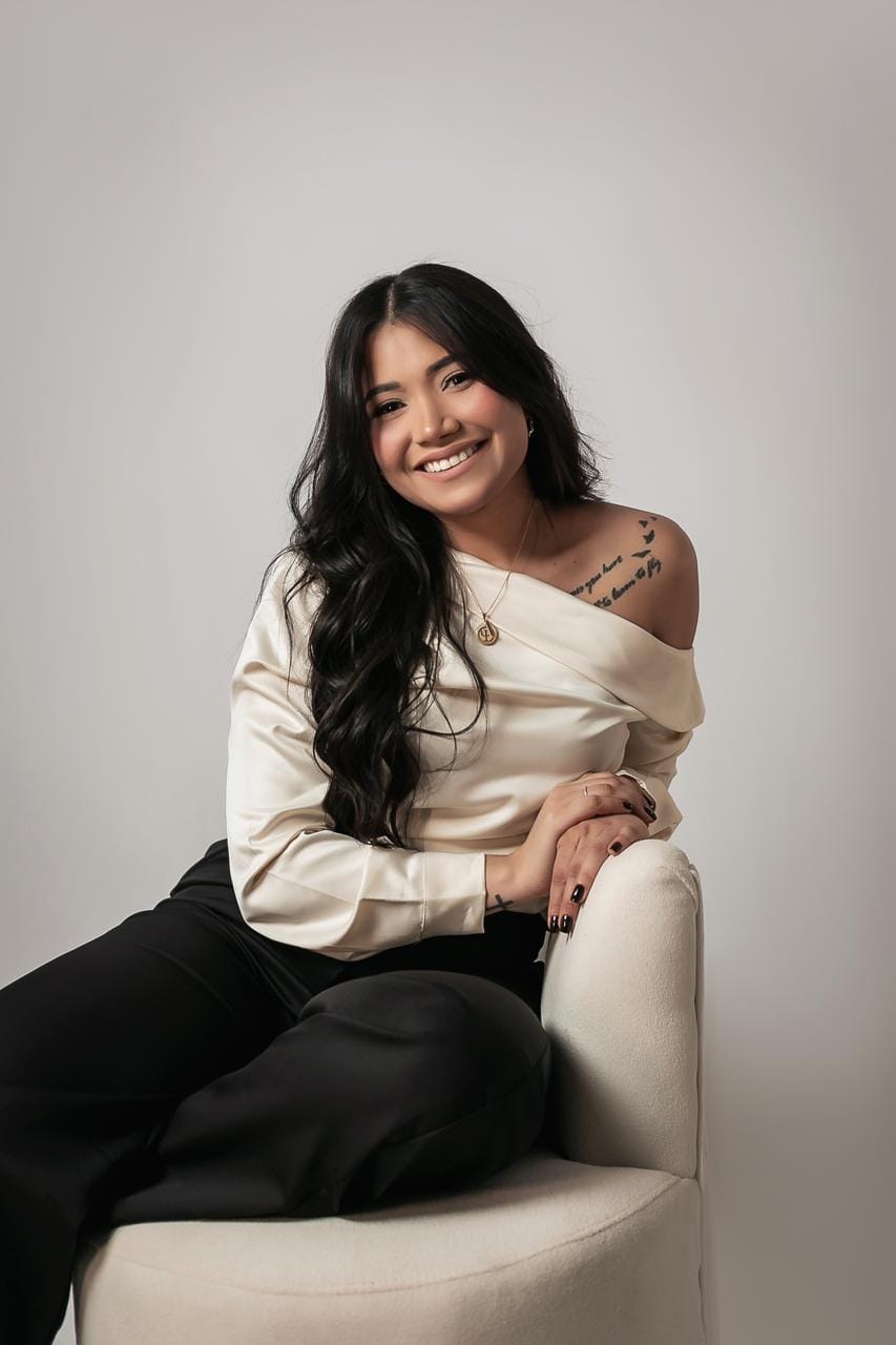 Maiara Nascimento em atendimento online, sentada à mesa com notebook