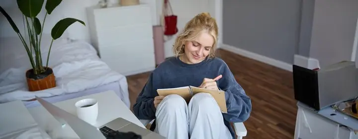 Mulher escrevendo em um diário, representando autoconhecimento